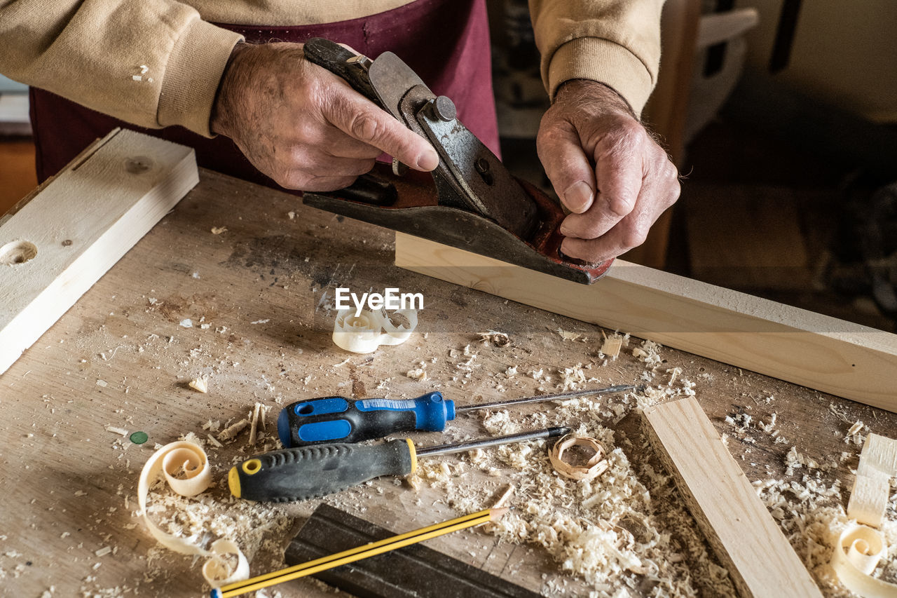 Midsection of carpenter working on wood