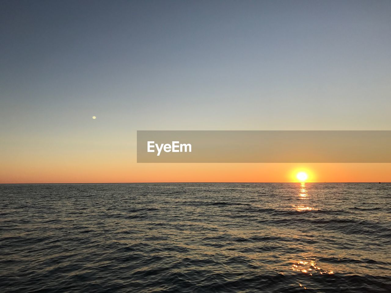 Scenic view of sea against clear sky during sunset