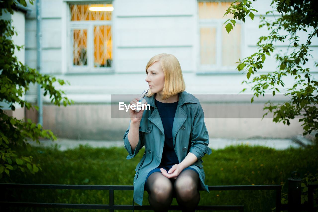 Beautiful young woman smoking electronic cigarette