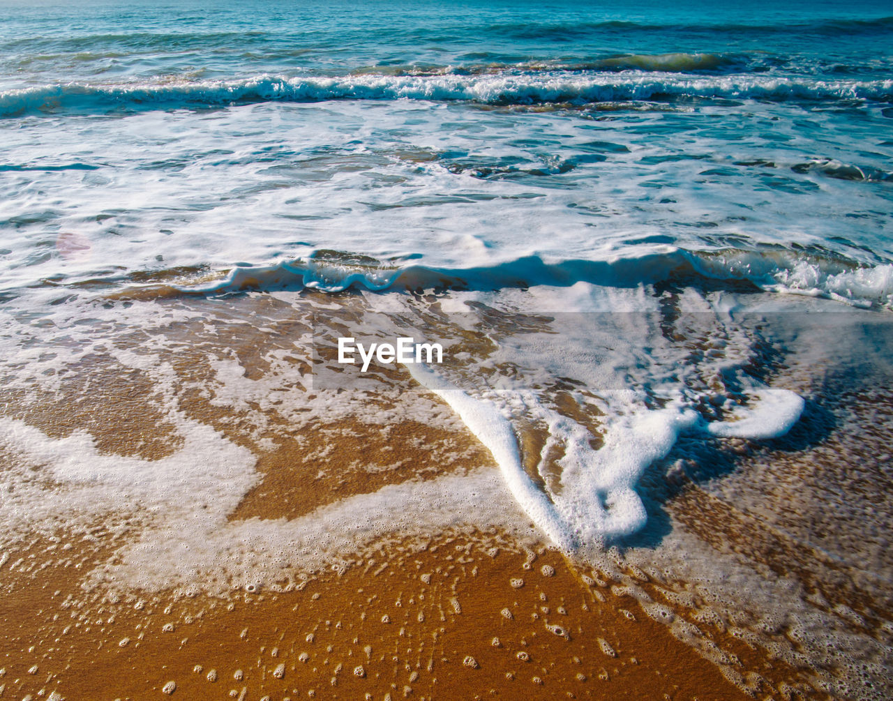 Close-up of wave on beach against sky