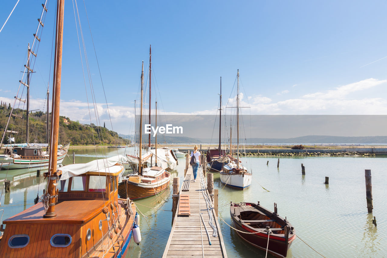 SAILBOATS MOORED AT HARBOR