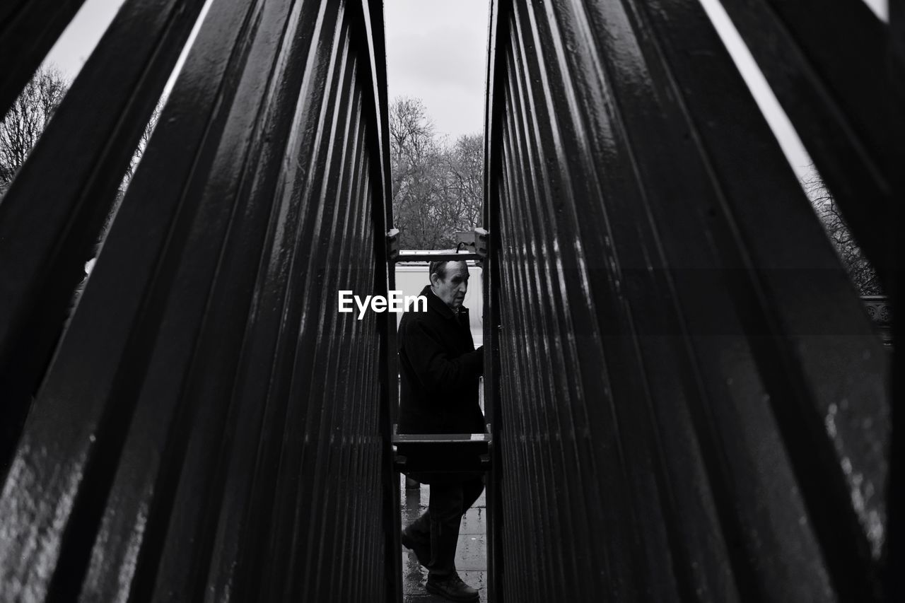 Side view of man seen through railing