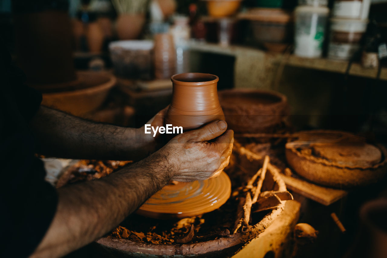Hands of potter holding earthen vase