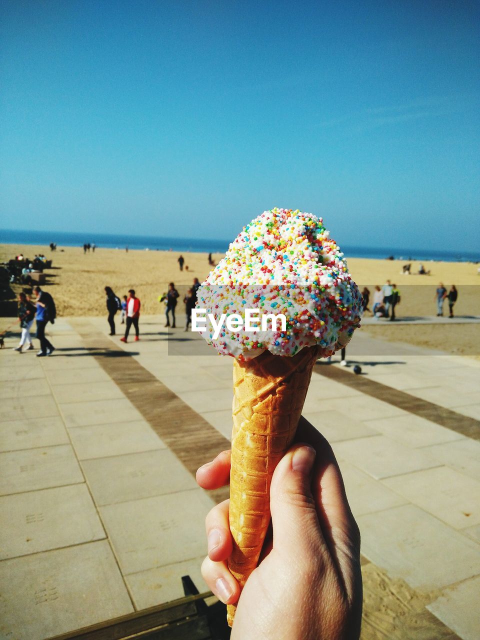 Close-up of hand holding ice cream at beach