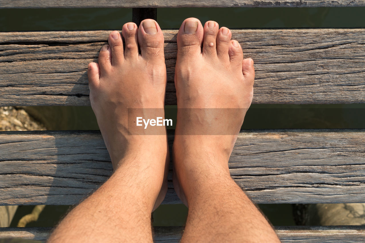 Low section of man standing barefoot