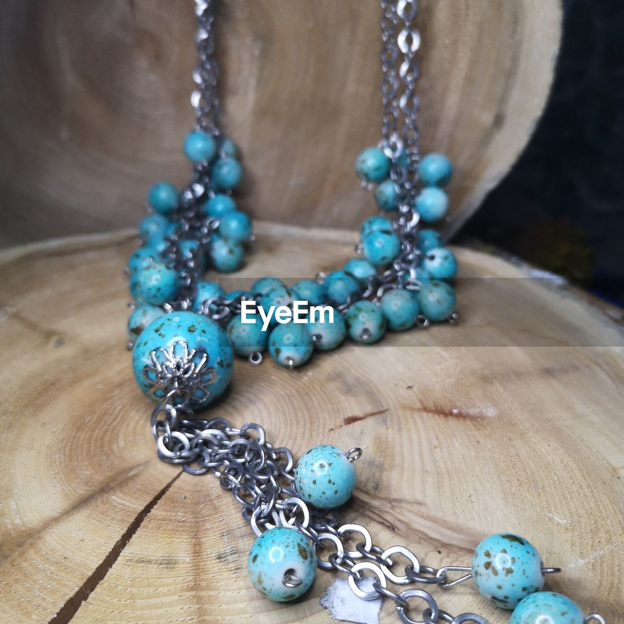 HIGH ANGLE VIEW OF NECKLACE ON BLUE TABLE