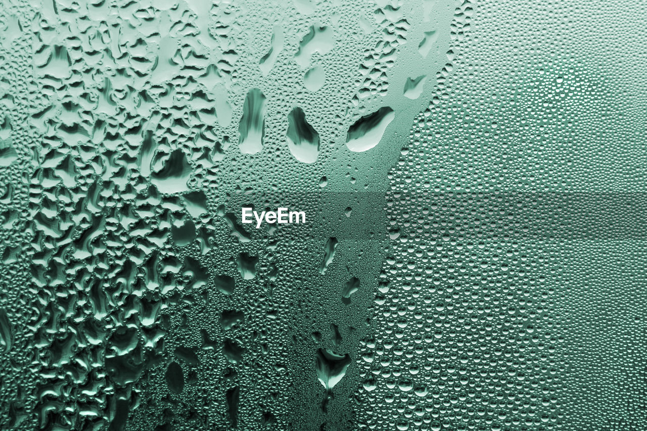 Natural large and fine water drops on glass