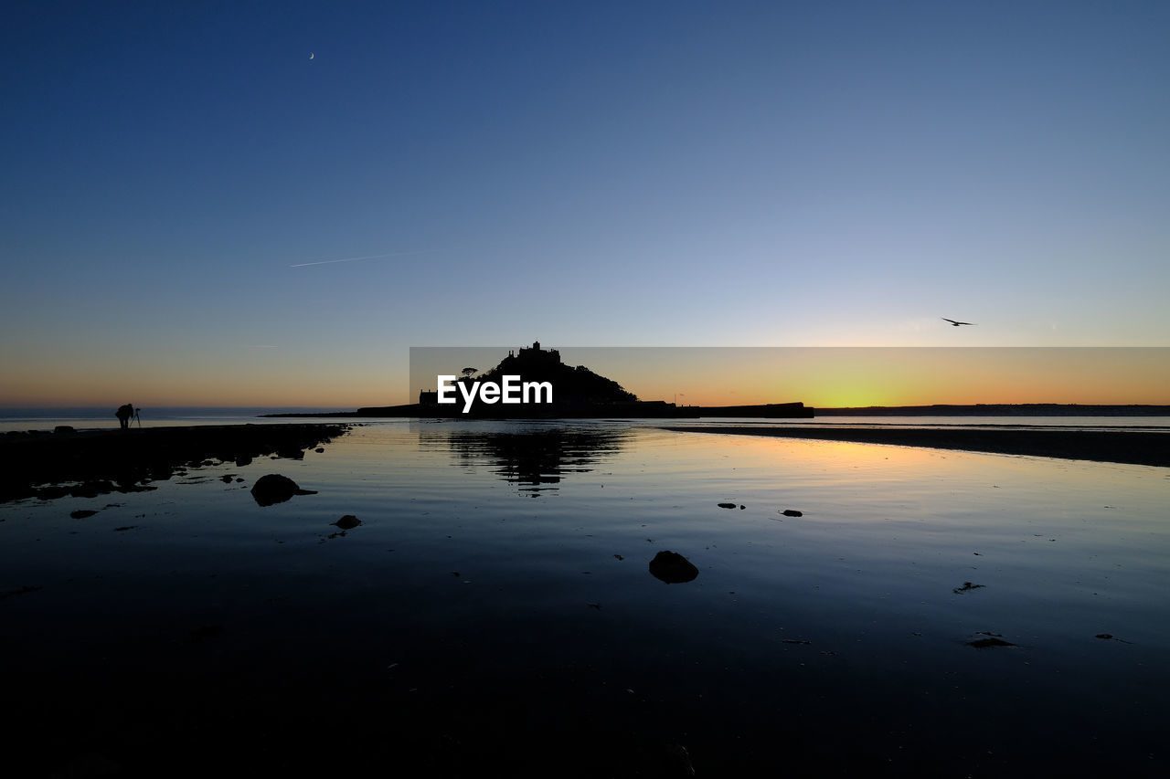 Scenic view of sea against clear sky during sunset