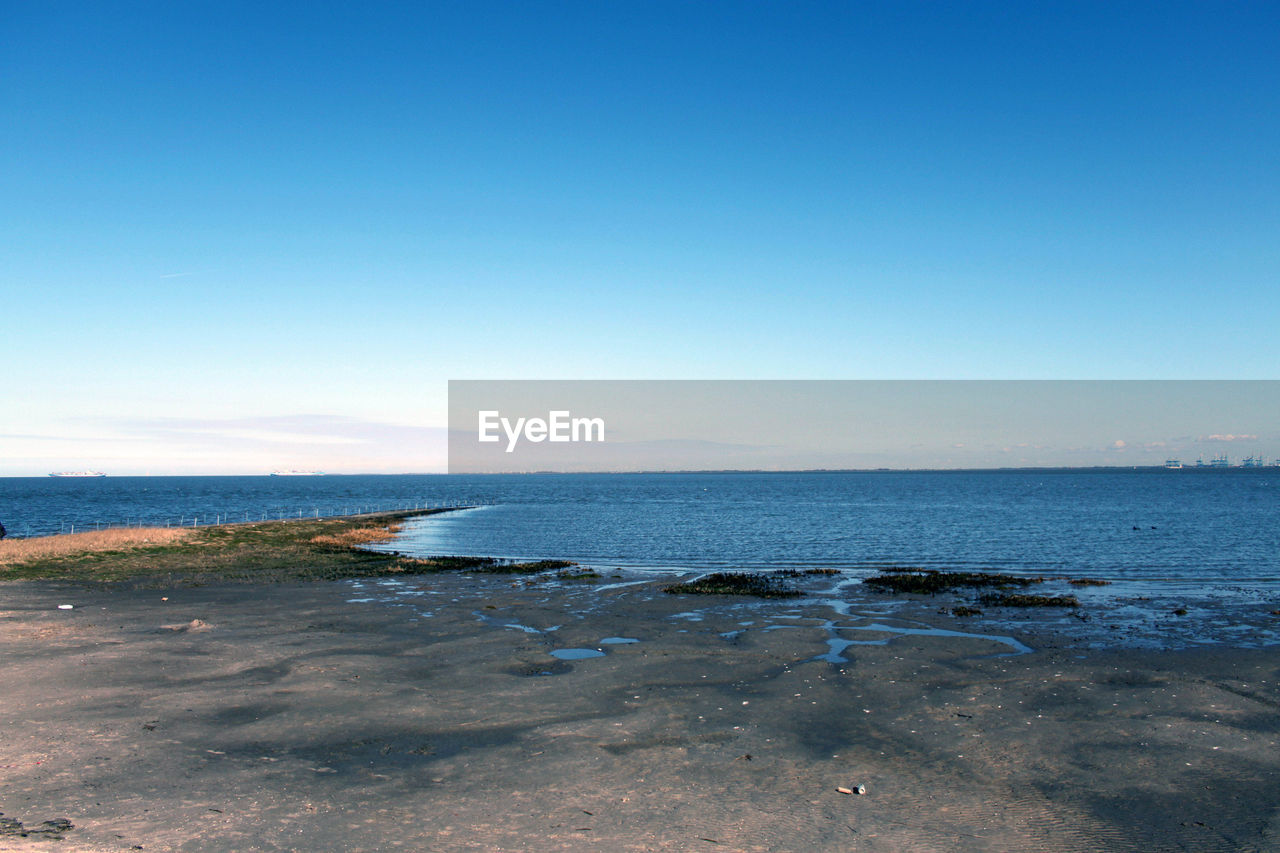 Scenic view of sea against clear blue sky