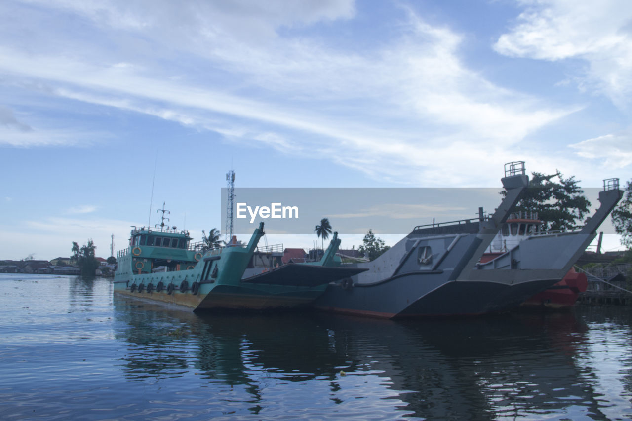 FISHING BOATS MOORED AT SEA AGAINST SKY