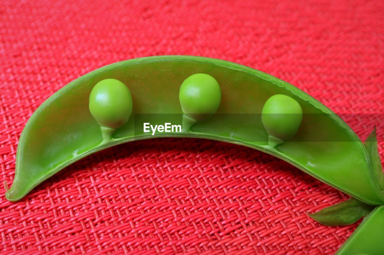 Close-up of green peas on red mat