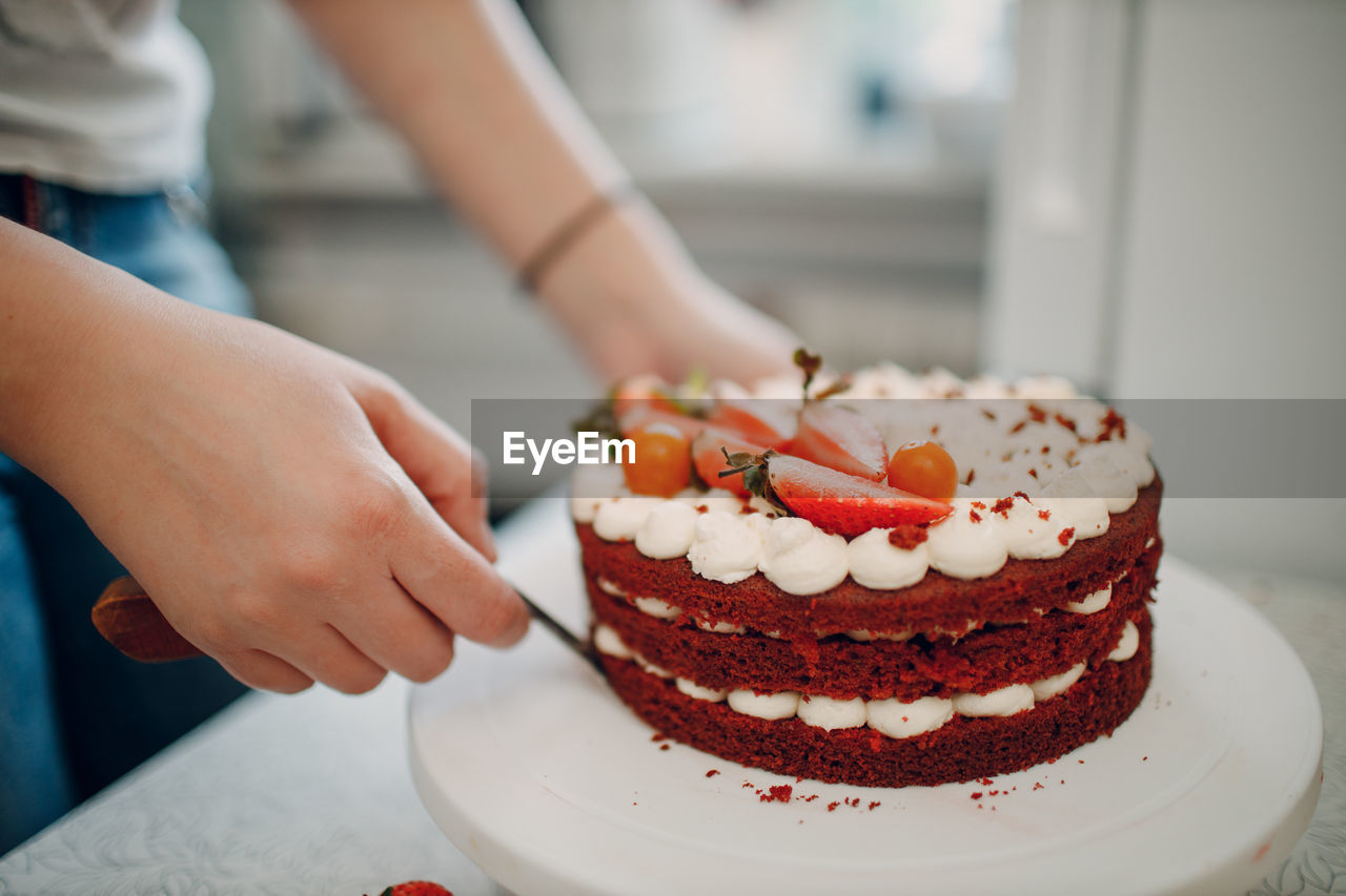 Midsection of woman keeping cake on stand at home