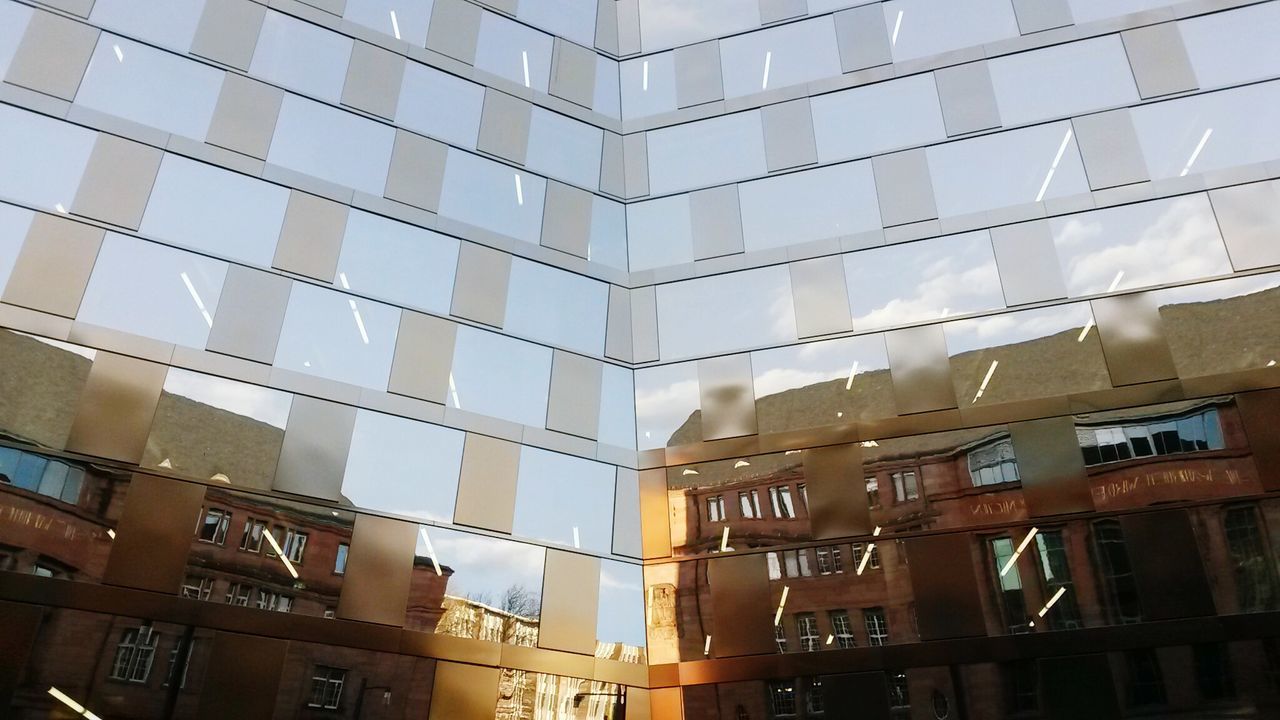 Low angle view of reflection on glass building