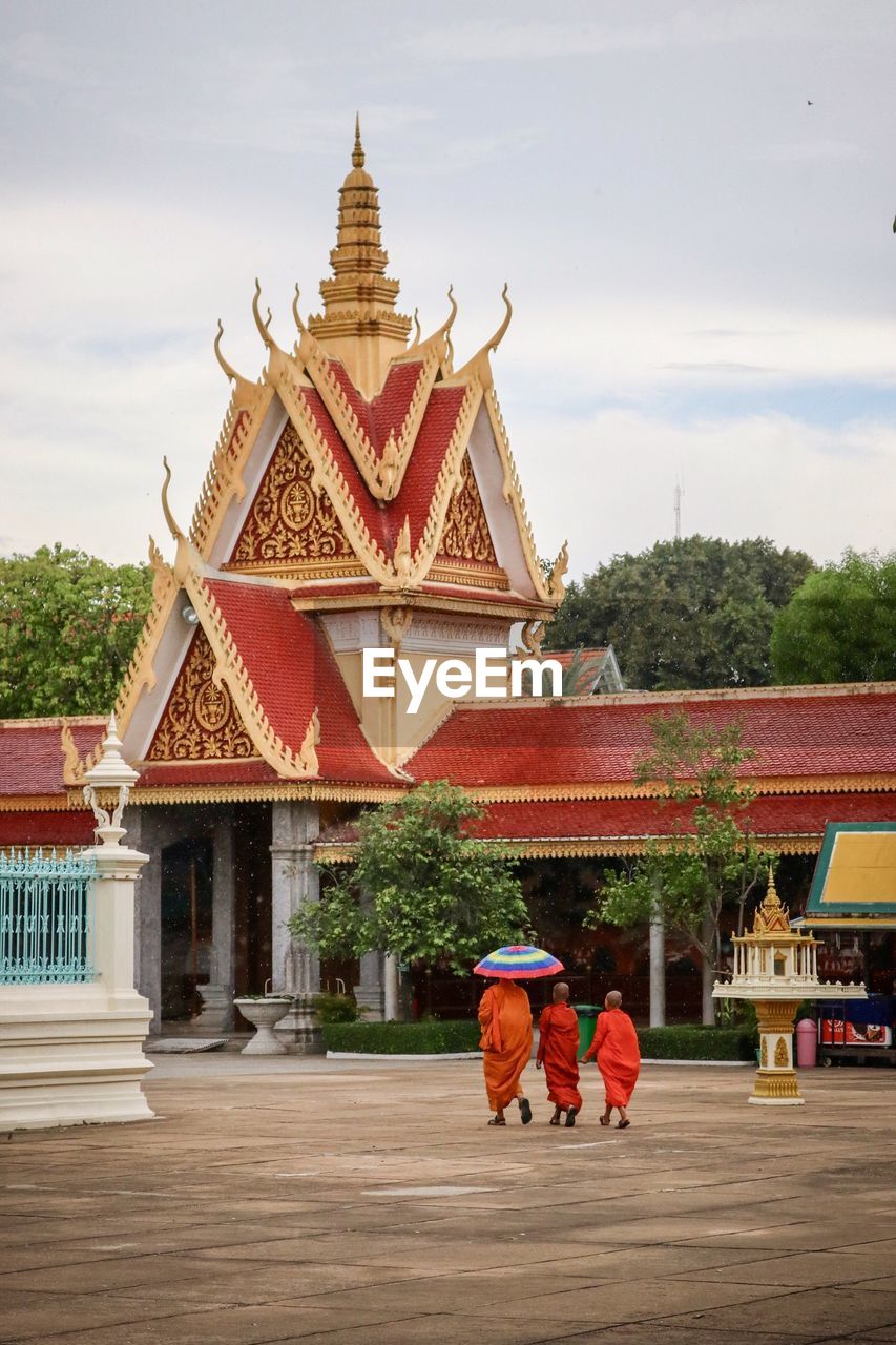 GROUP OF PEOPLE IN TEMPLE AGAINST BUILDING