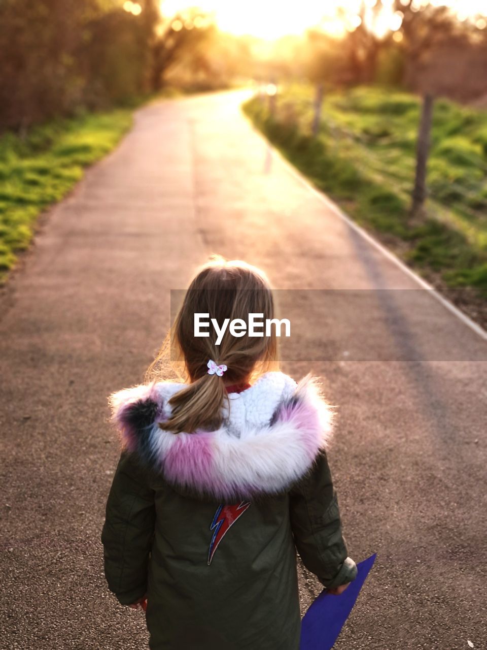 Rear view of girl standing on road