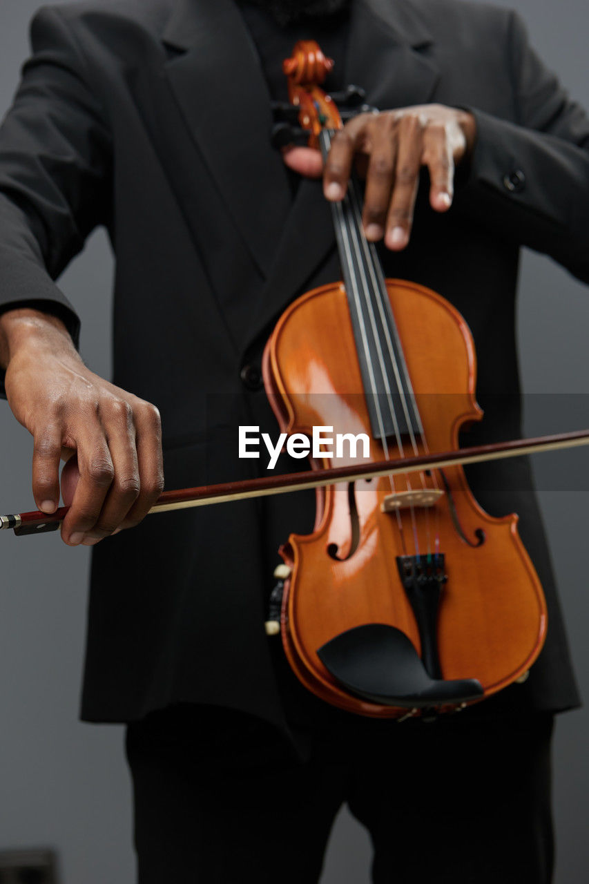 midsection of businessman playing violin