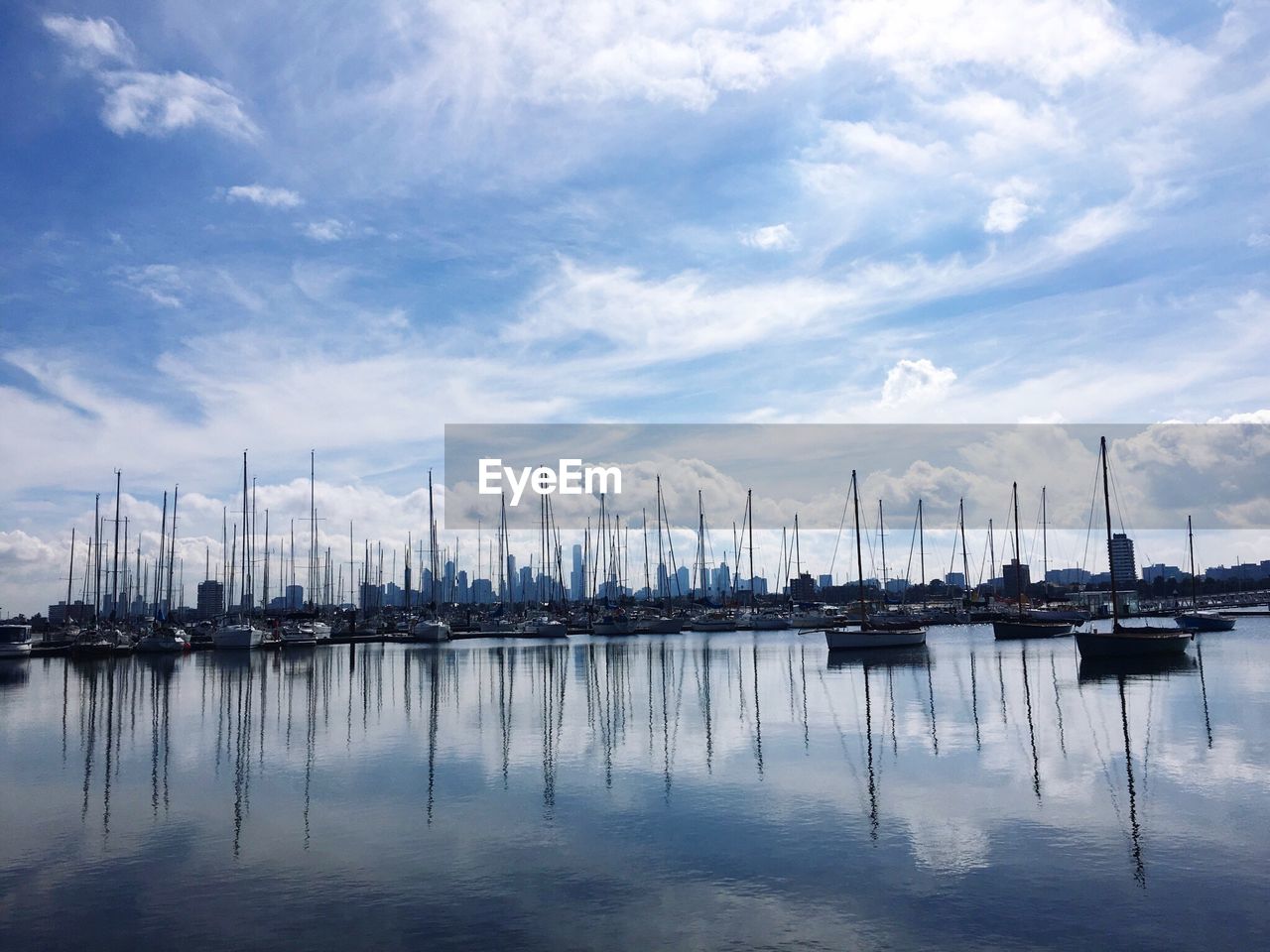 Sailboats moored on sea against sky