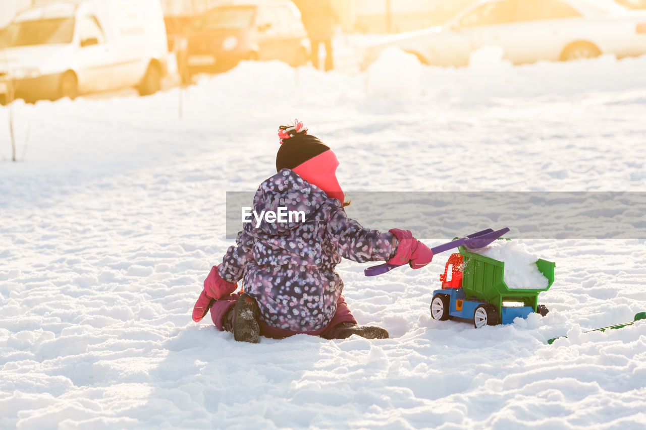 FULL LENGTH OF GIRL PLAYING WITH SNOW