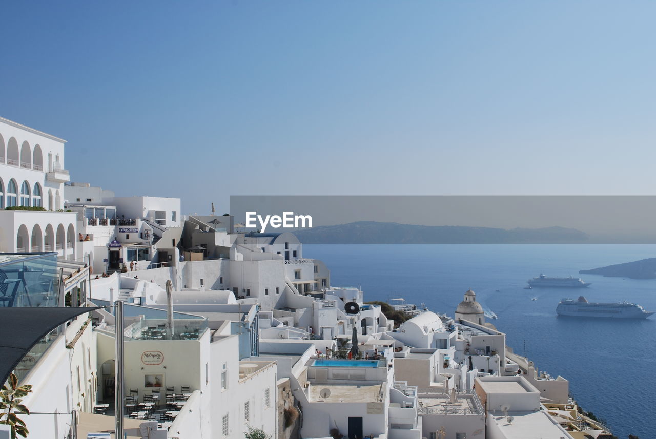 High angle view of buildings by sea against clear sky