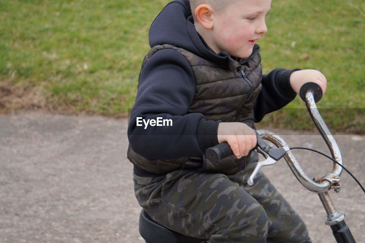 Side view of boy riding bicycle