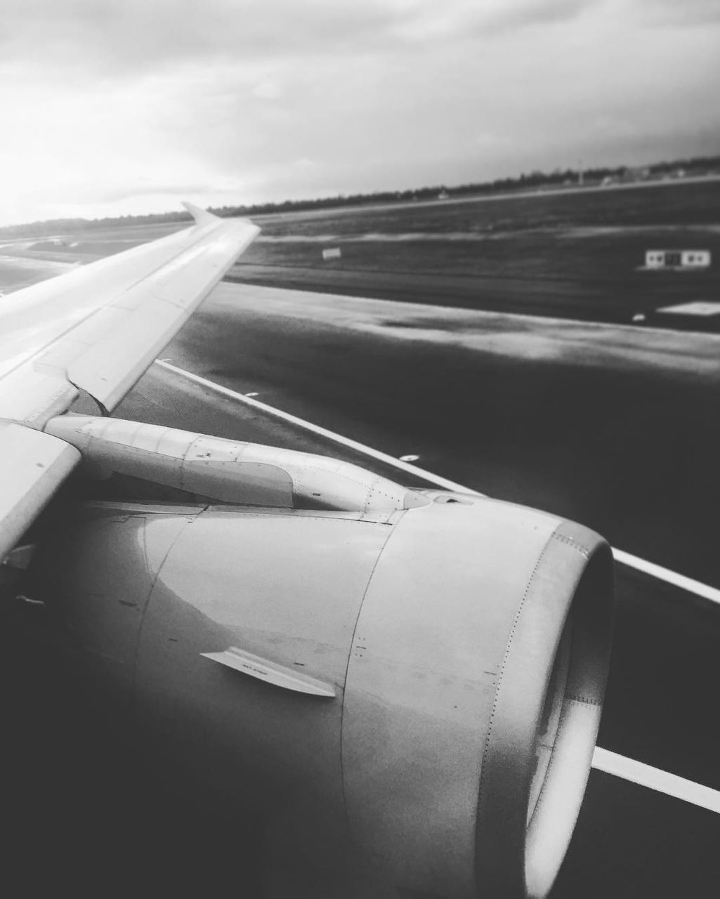 CROPPED IMAGE OF AIRPLANE WING OVER LANDSCAPE