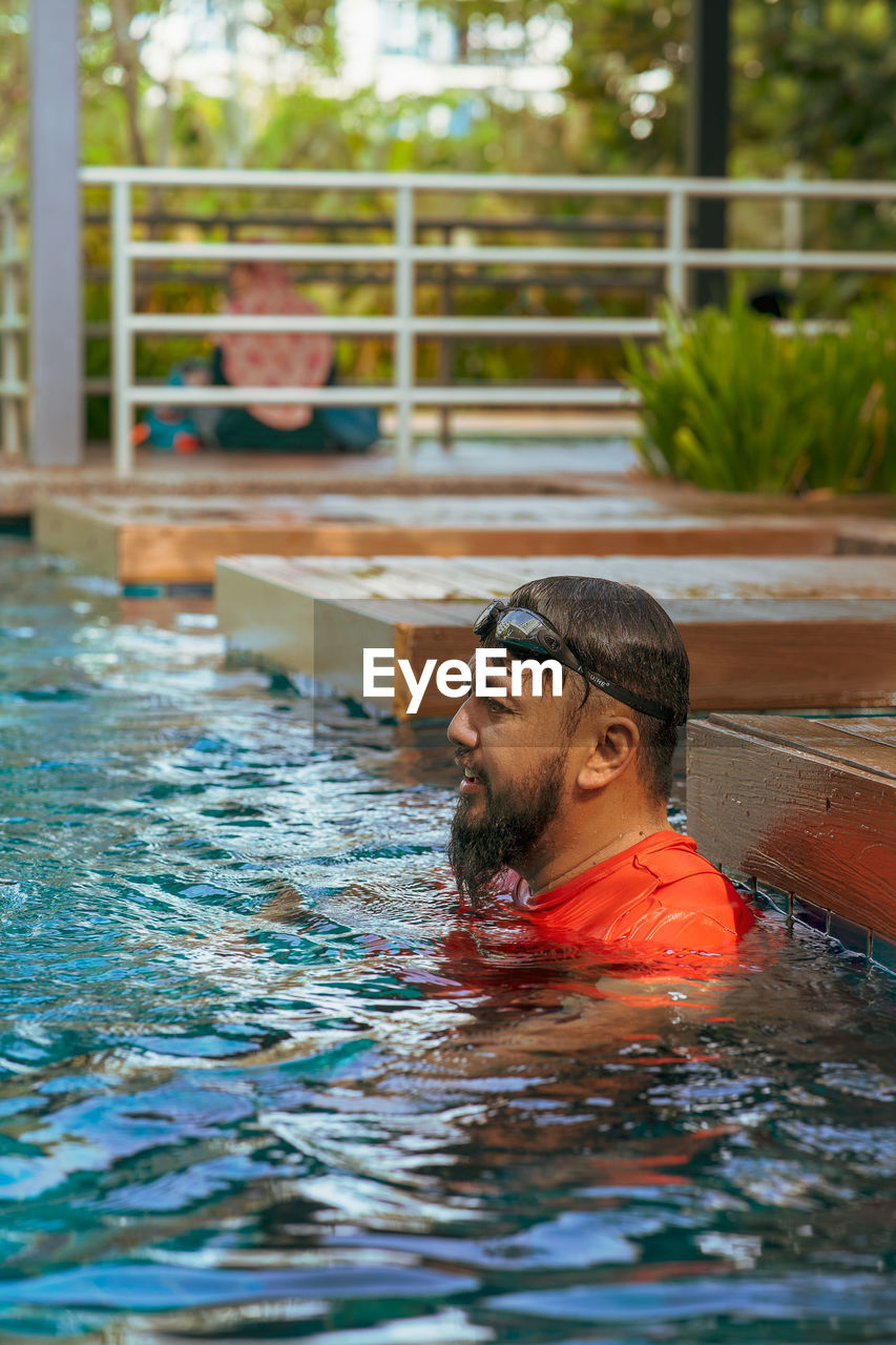 Bearded man relaxing in the swimming pool. summer vacation