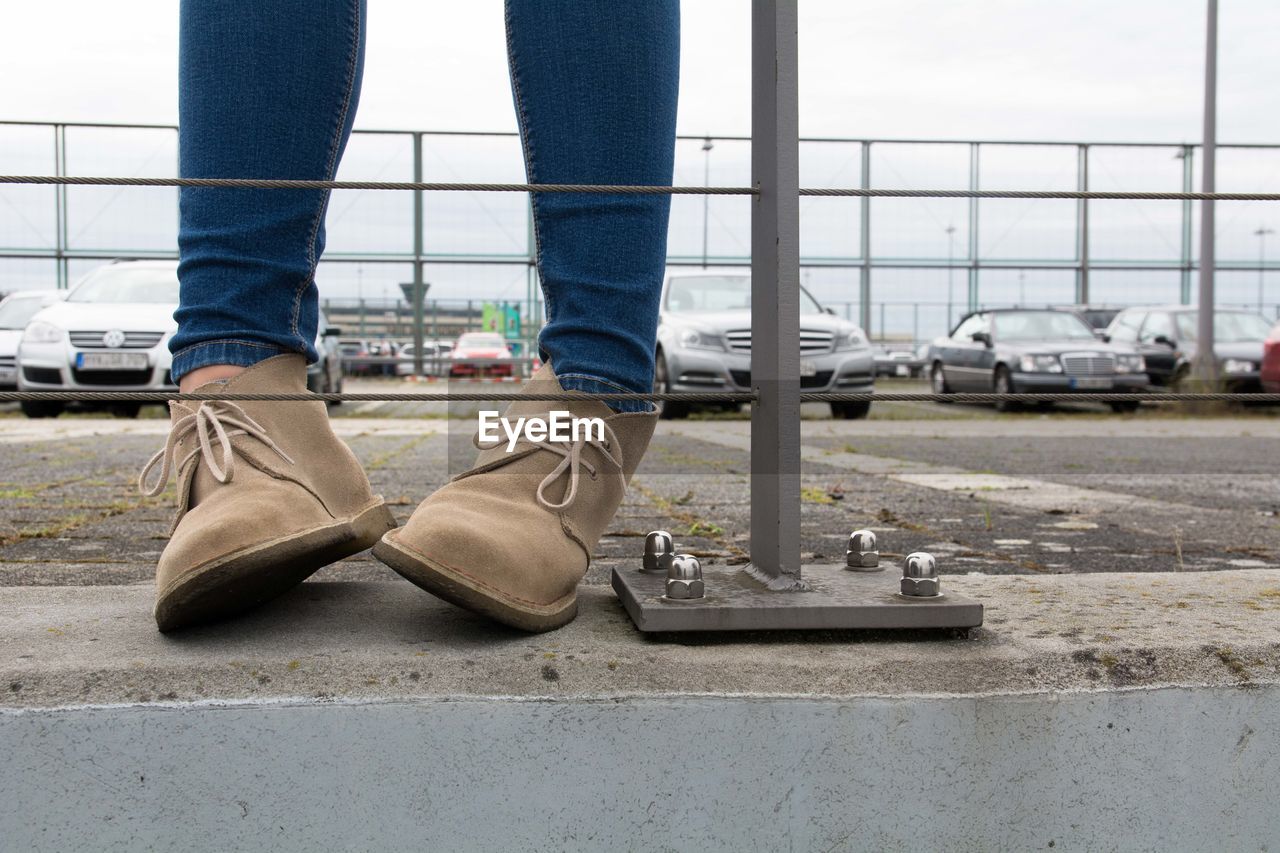 Low section of person standing by railing