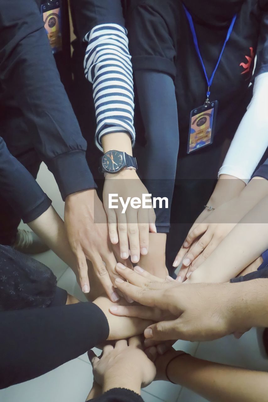 group of people, adult, women, togetherness, hand, limb, human leg, men, cooperation, unity, group, young adult, teamwork, medium group of people, female, clothing, indoors, friendship, person, sitting, bonding, midsection