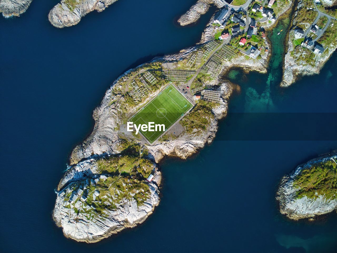 HIGH ANGLE VIEW OF SEA BY BUILDINGS AGAINST BLUE SKY