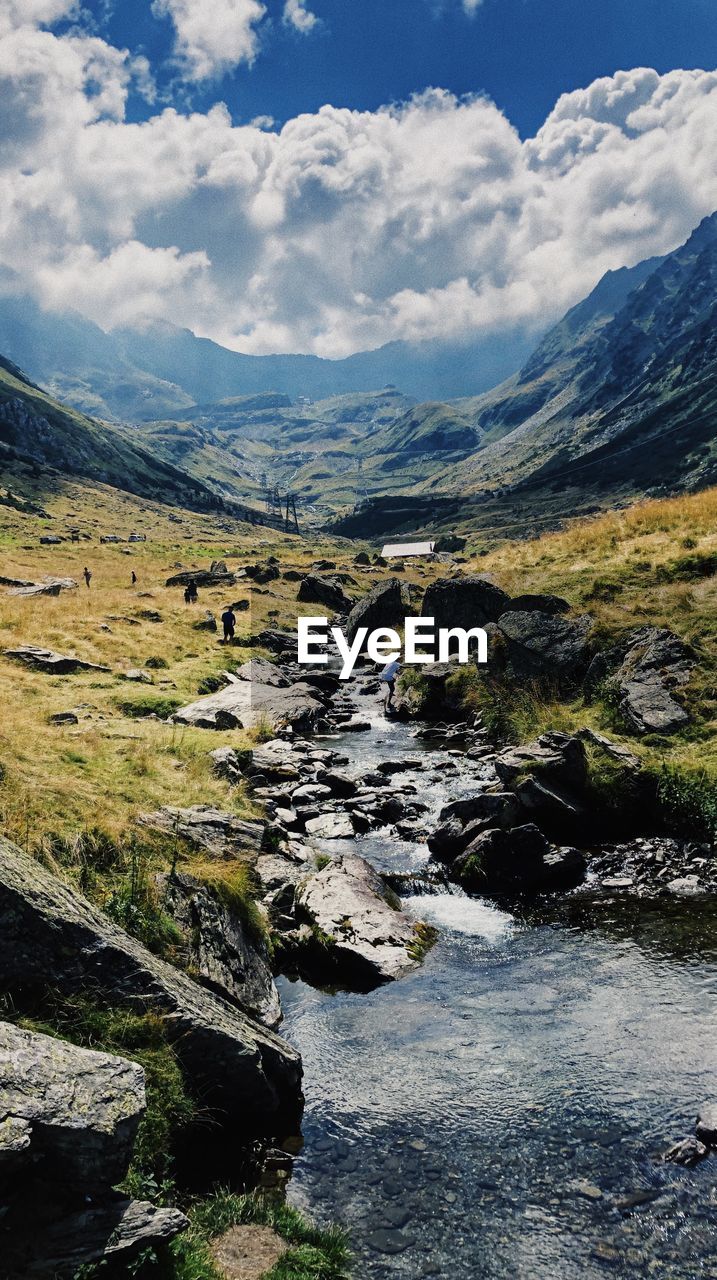 Scenic view of river amidst mountains against sky