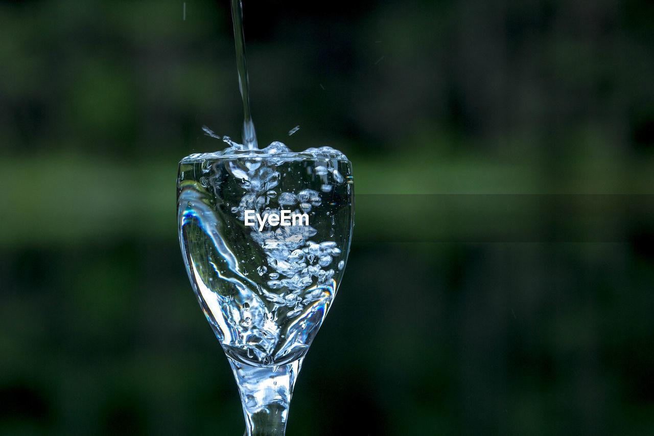 Water pouring in wineglass