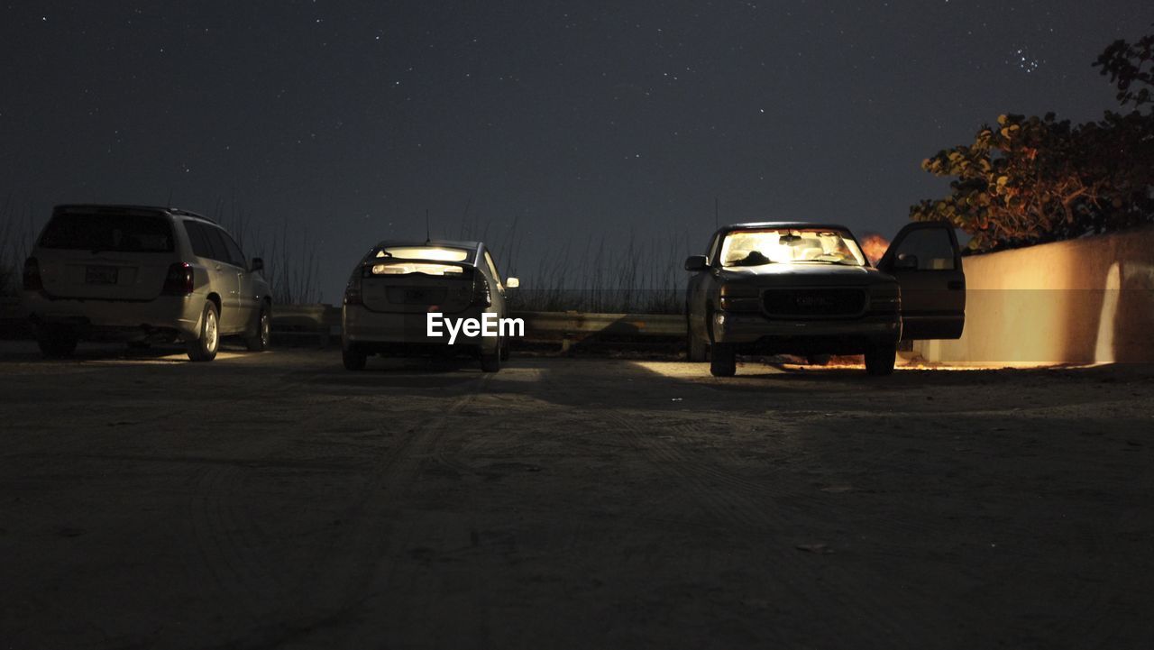 Vehicles parked against the sky at night