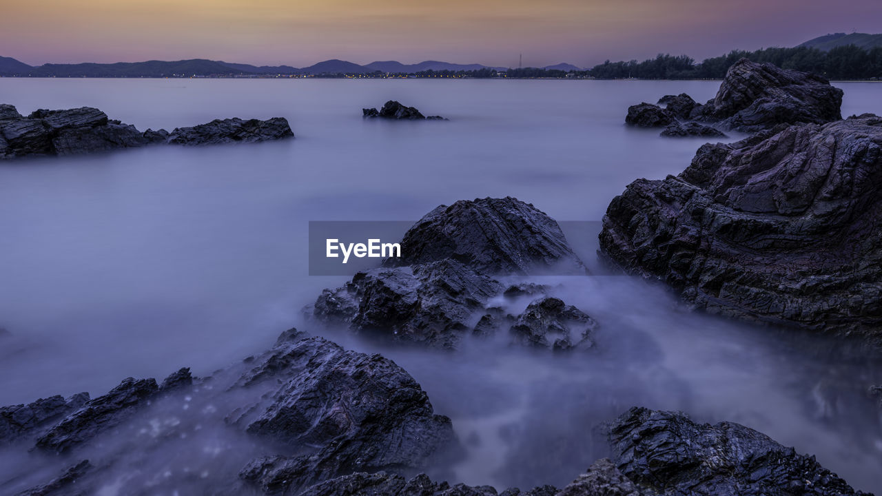 Long exposure of water in sea during sunset