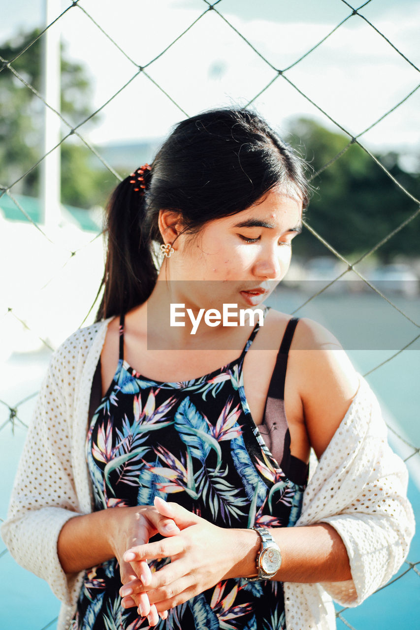 Young woman standing by net in court