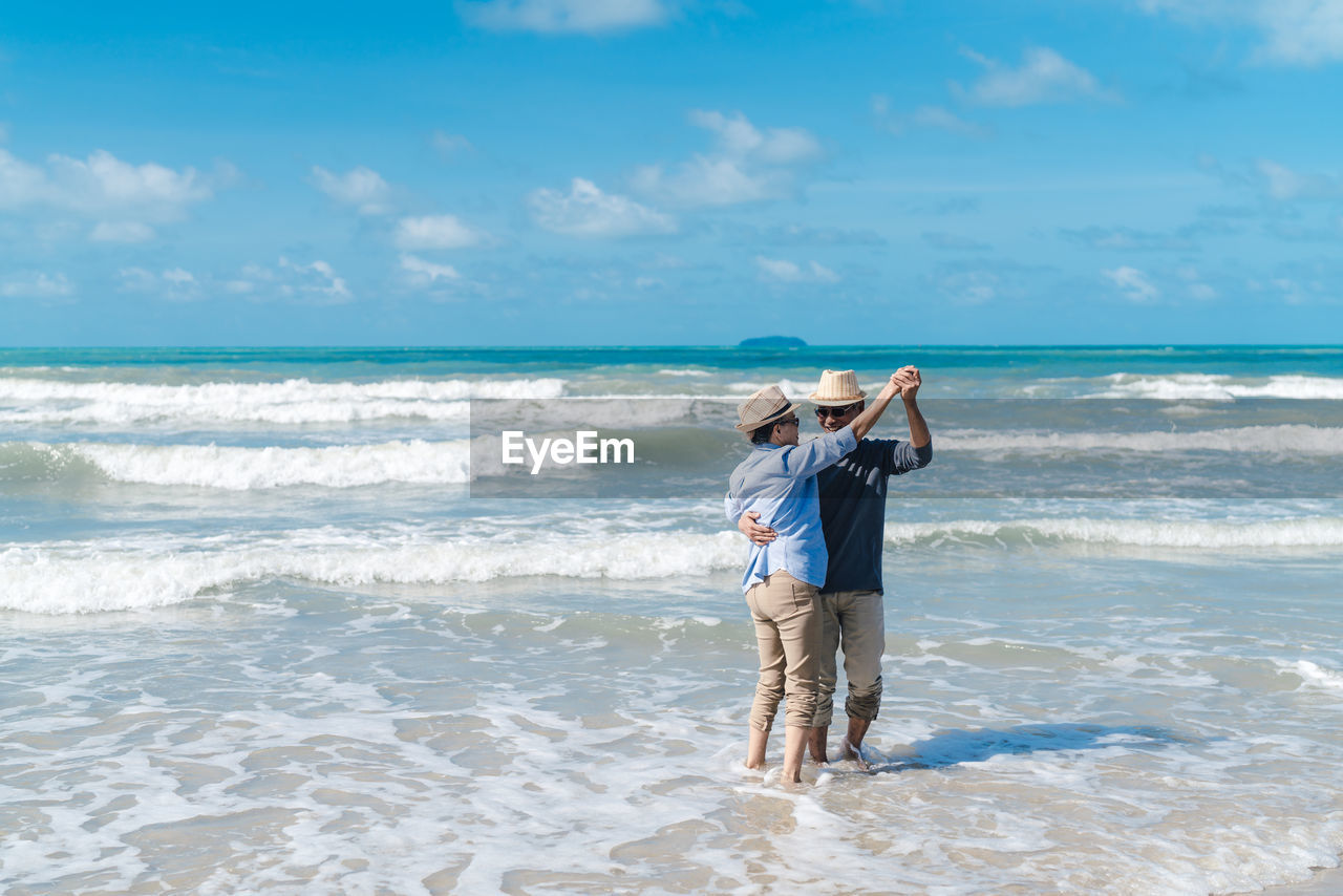 FULL LENGTH OF MAN STANDING ON BEACH