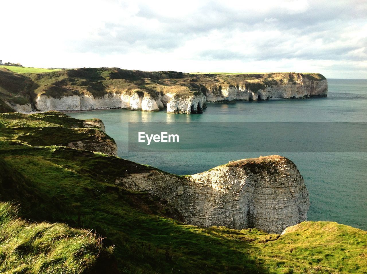 Scenic view of cliff by sea against sky