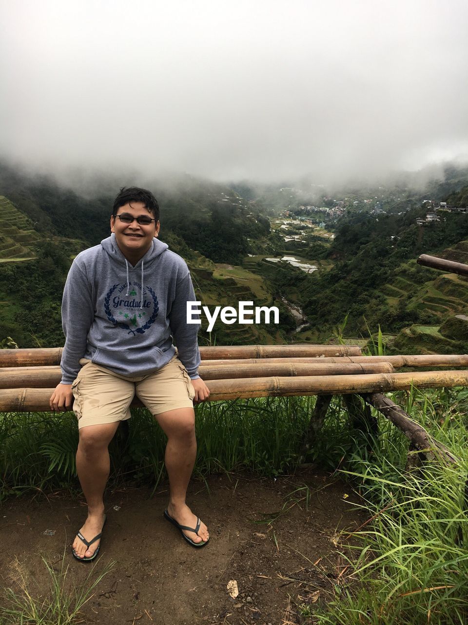 Portrait of young man sitting against mountain