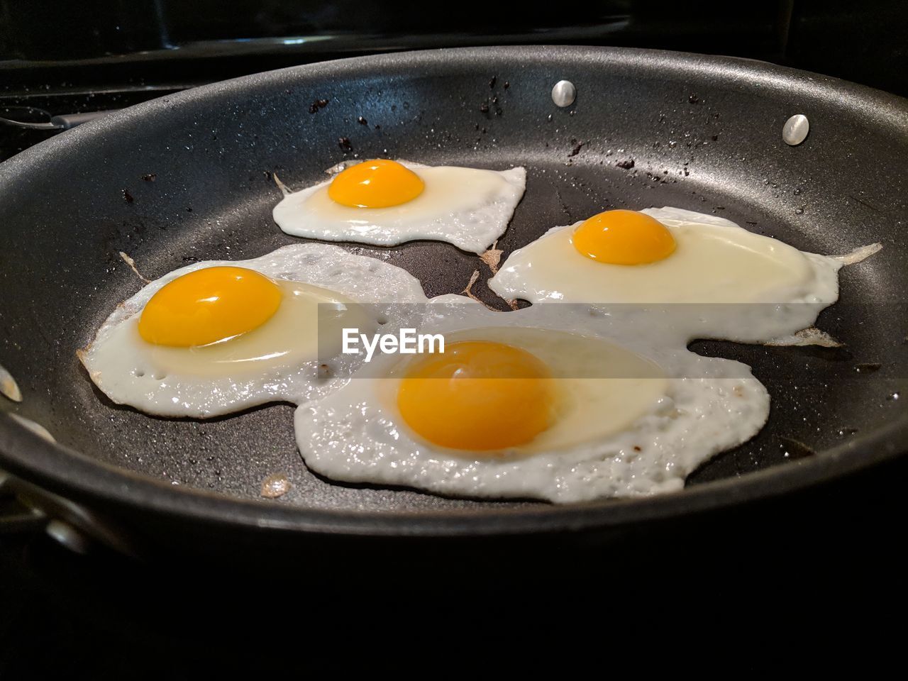 Close-up of fried eggs preparing in cooking pan