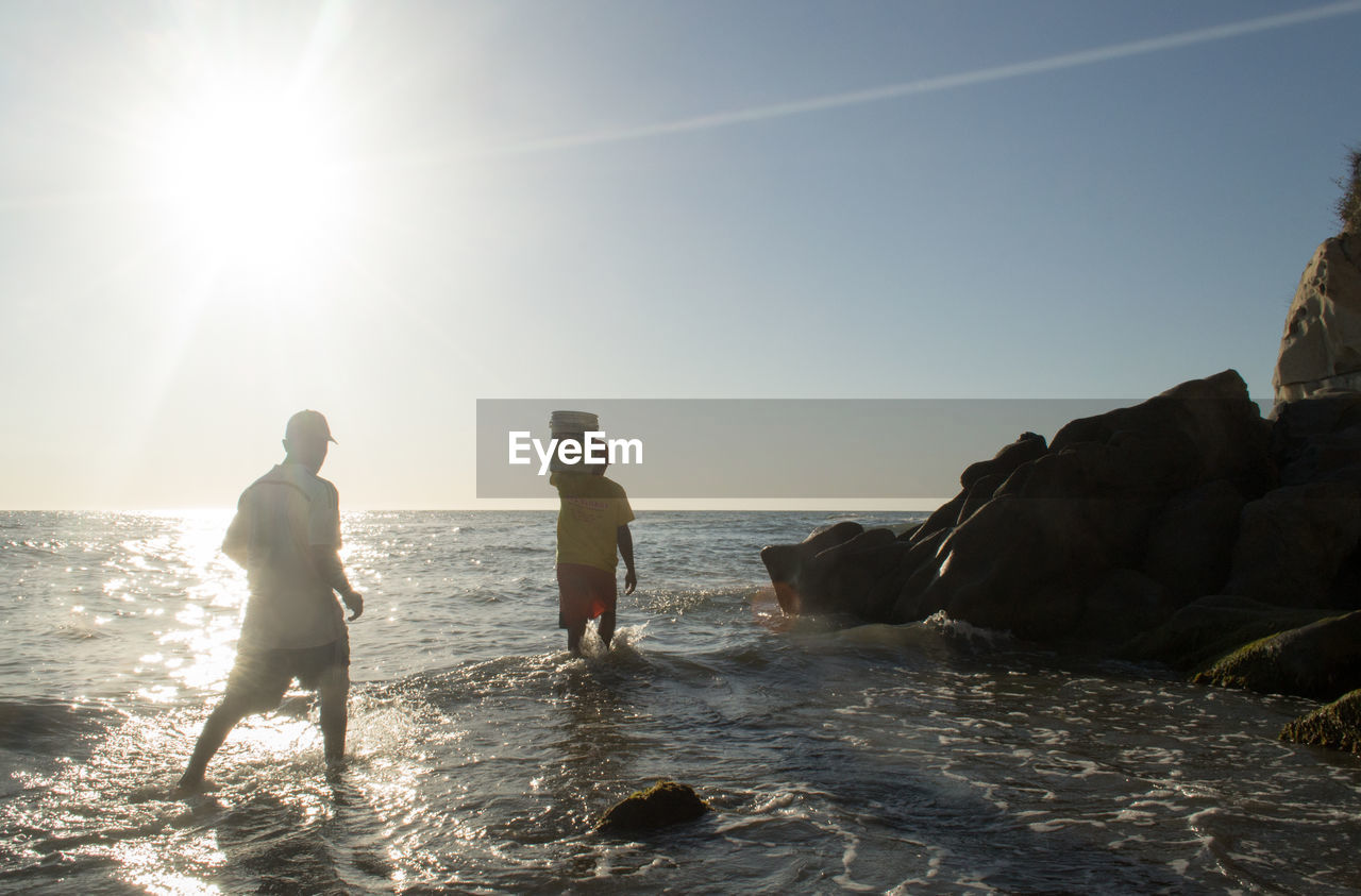 MEN PLAYING AT BEACH