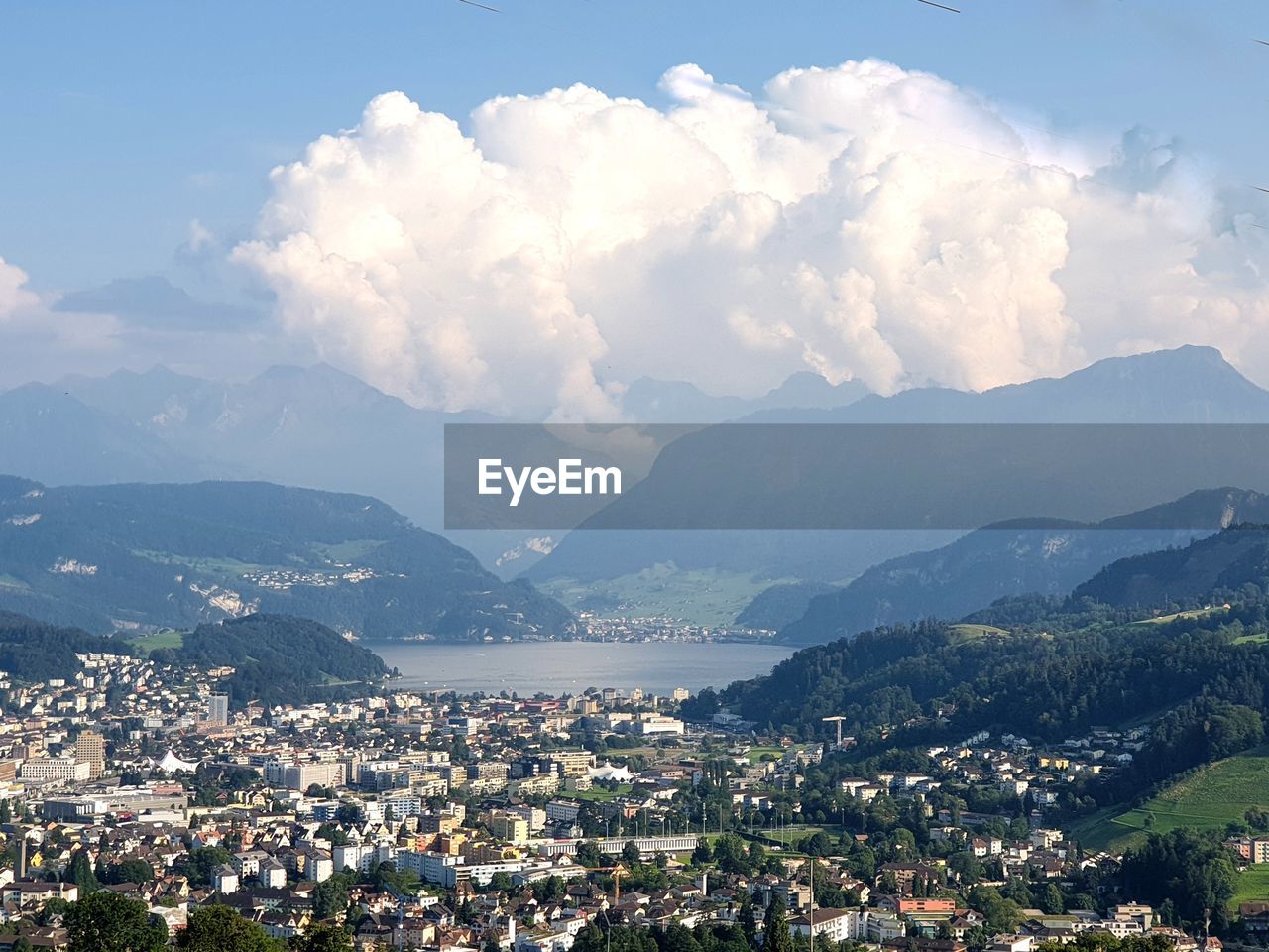 Aerial view of townscape and mountains against sky