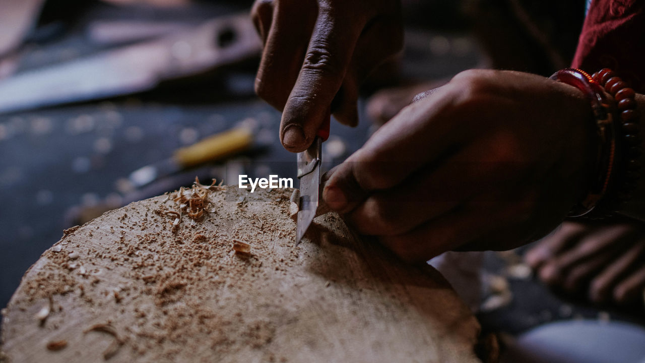 The hand of a wood craftsman carving wood 