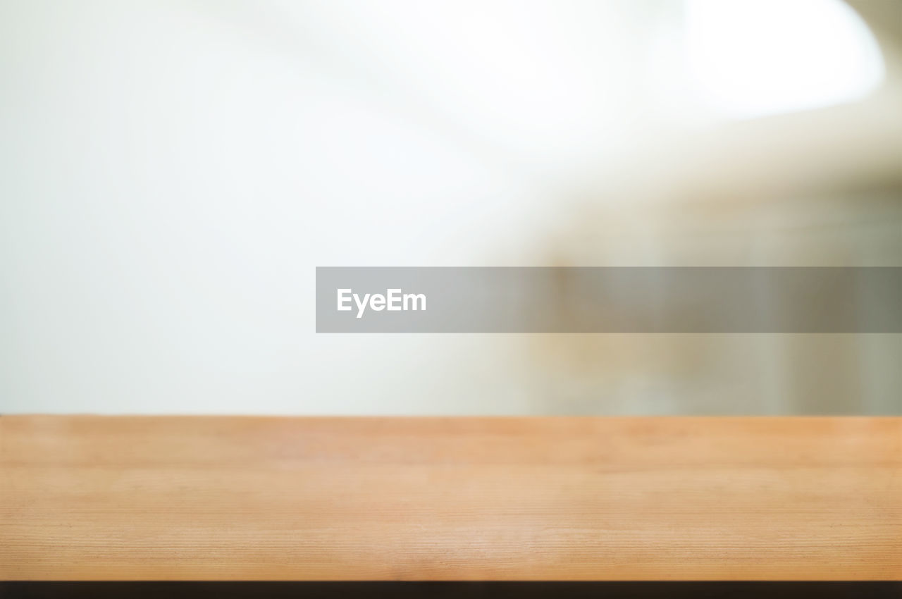 CLOSE-UP OF WOODEN TABLE ON HARDWOOD FLOOR
