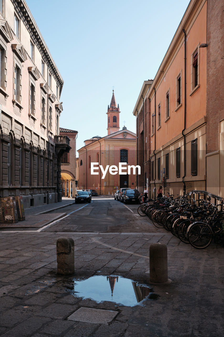 STREET AMIDST BUILDINGS AGAINST CLEAR SKY