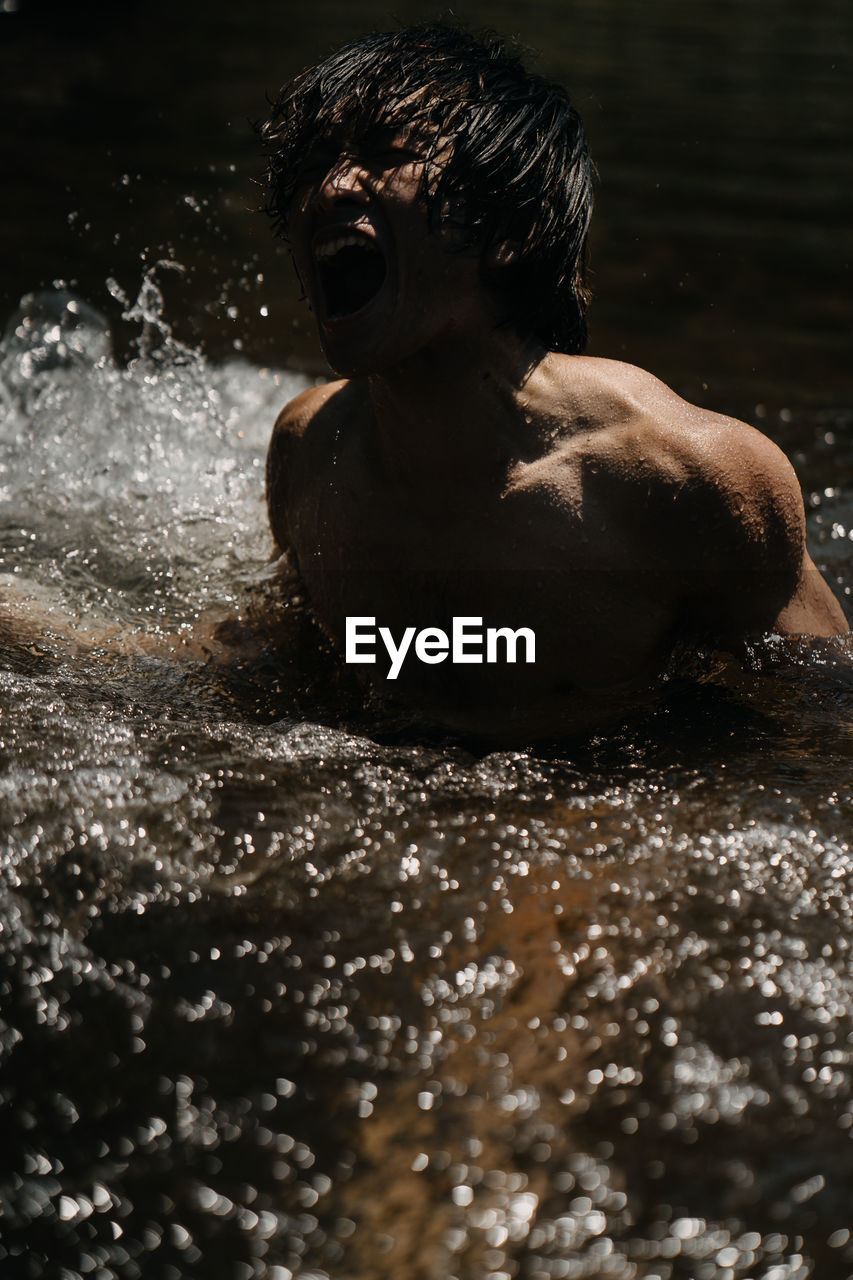 Portrait of shirtless man in water