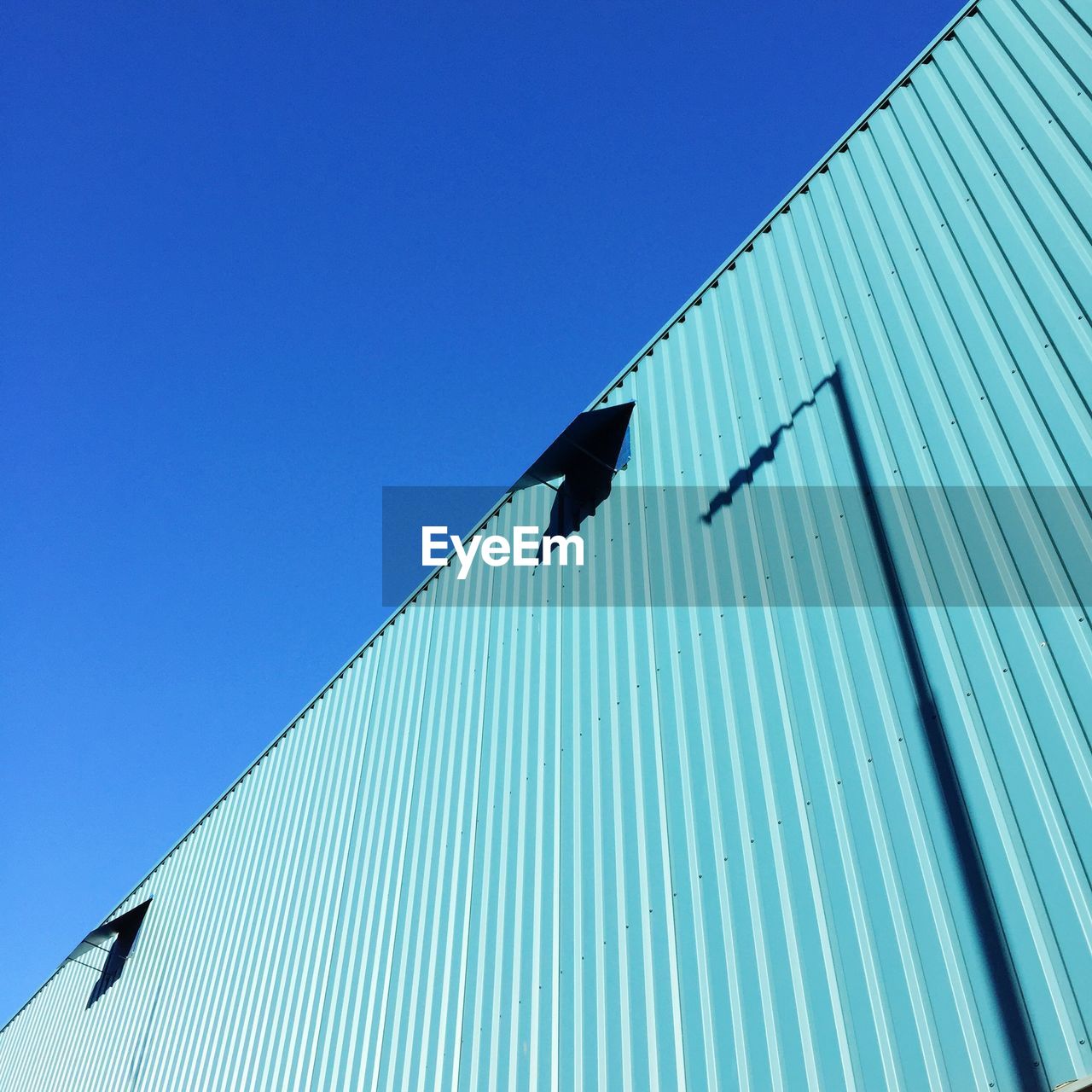 Low angle view of metal structure against blue sky