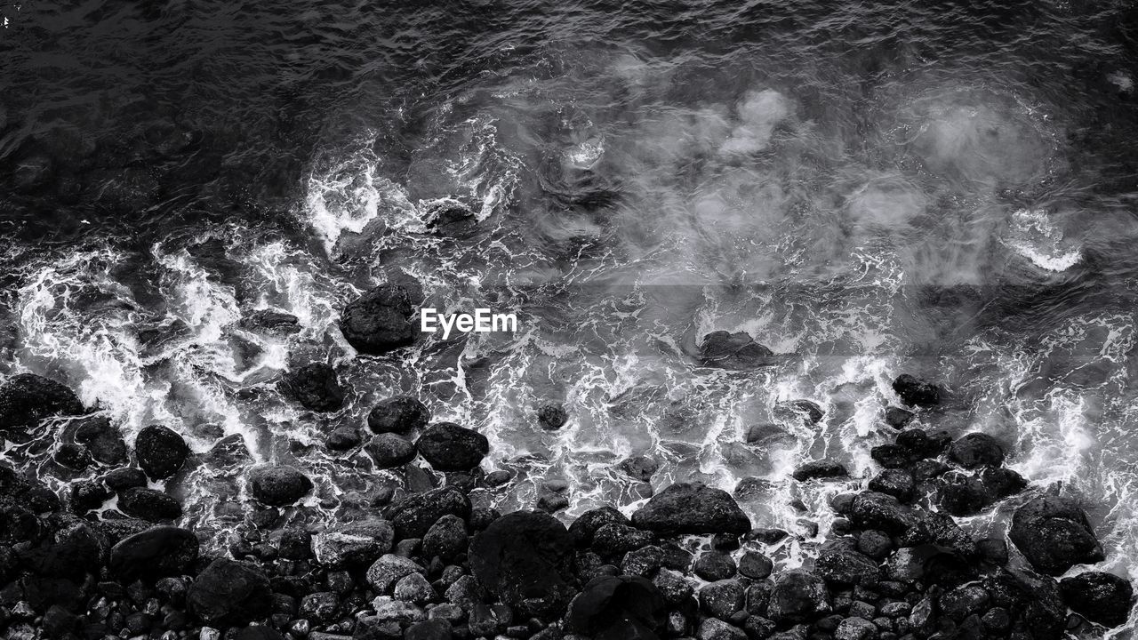 FULL FRAME SHOT OF ROCKS AT SEA