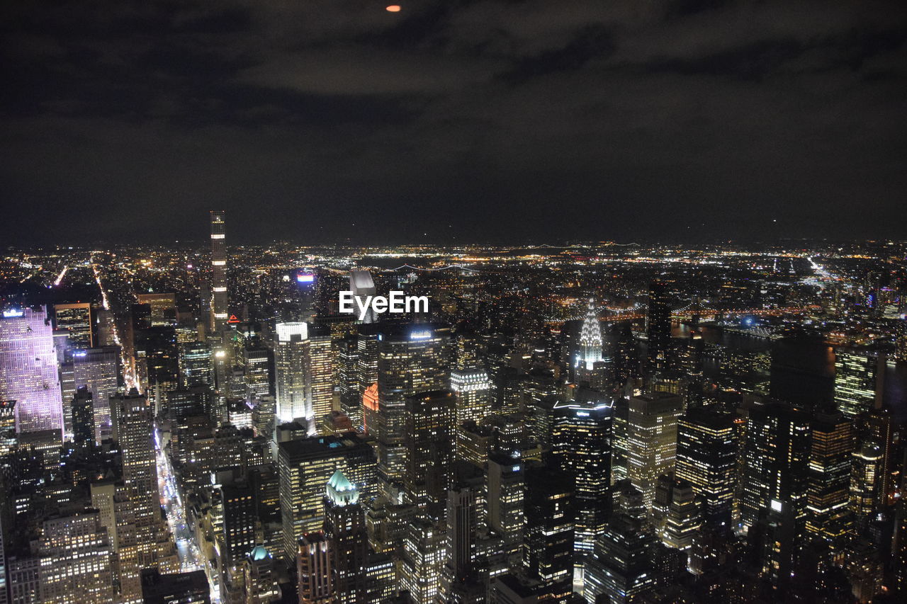 Illuminated cityscape against sky at night