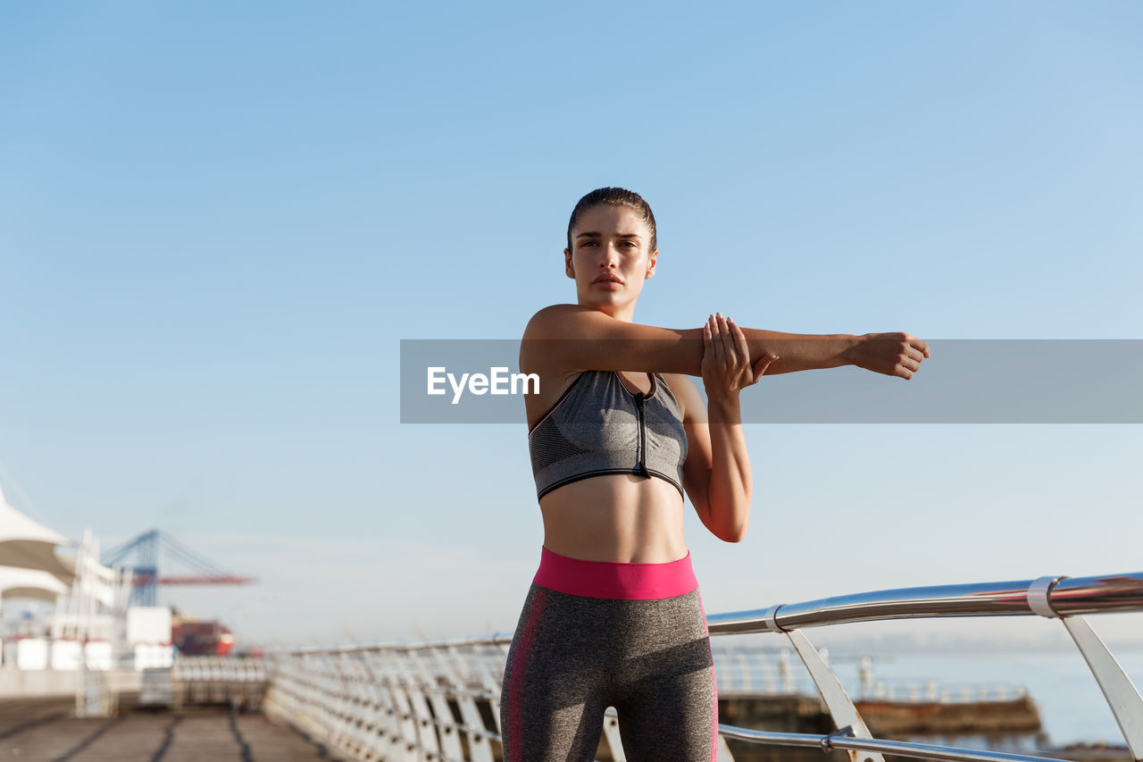 Woman exercising against sky