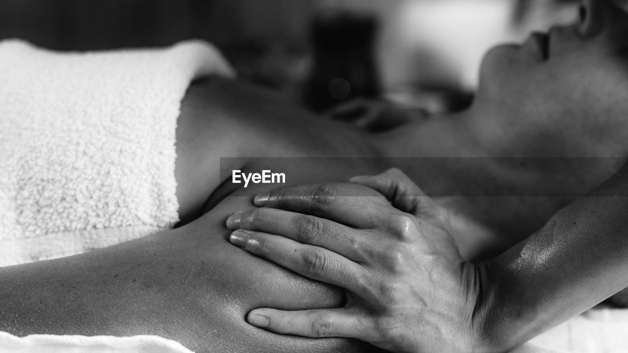 Woman enjoying ayurvedic shoulders massage with ethereal oils