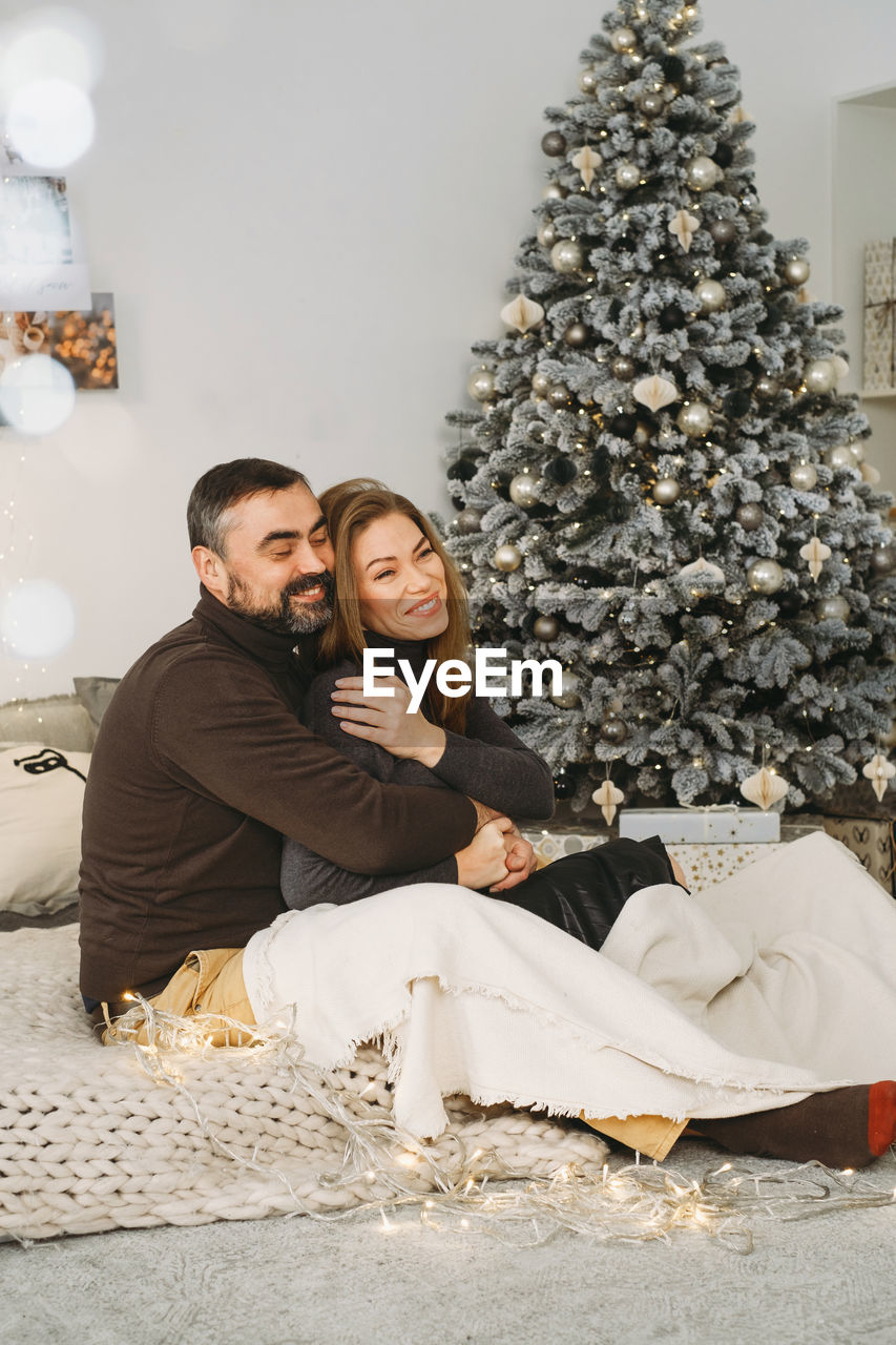 Happy couple celebrating romantic christmas eve at home. christmas interior decoration for family